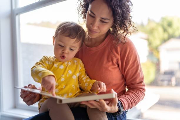 Parent reading picture book with toddler to support language and speech development
